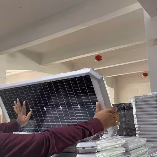 Ein Arbeiter inspiziert die Solarpanel-Baugruppe einer FXC-Kamera-Solarstraßenlaterne im Werk.