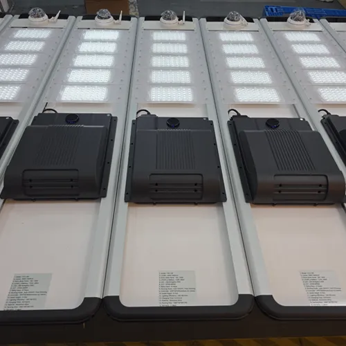 Solar street light units with LED panels, rear housings, and camera modules in a factory