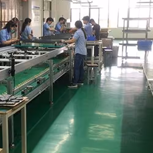 Des ouvriers assemblent des lampadaires de la série SQ sur la chaîne de production de l'usine.