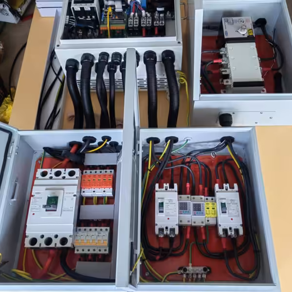 Innenansicht der Steuerkästen eines SY-Solarstromsystems mit Leistungsschaltern, Klemmen und elektrischer Verkabelung