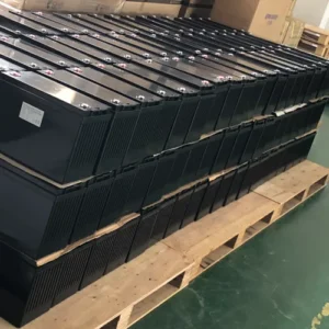 Bulk black LiFePO4 batteries neatly stacked on wooden pallets in the warehouse inventory