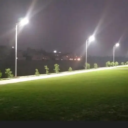 I lampioni a LED della serie LA di Sungreat Energy illuminano di notte un sentiero e un'area verde di un parco, dimostrando una distribuzione uniforme della luce e una visibilità nitida e brillante.