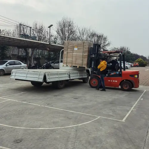 I lampioni solari integrati della serie QH di Sungreat Energy vengono caricati su un camion a pianale ribassato tramite un carrello elevatore, a dimostrazione dell'imballaggio sicuro su pallet e della gestione logistica professionale per la spedizione di grandi quantitativi.