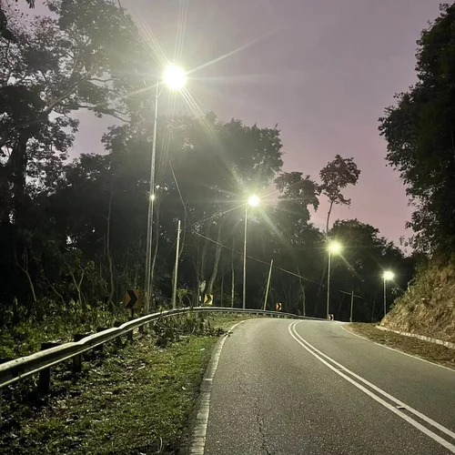 I lampioni solari multifunzione della serie QH di Sungreat Energy illuminano di notte una strada curva, dimostrando elevata luminosità e ampia copertura per la sicurezza stradale.