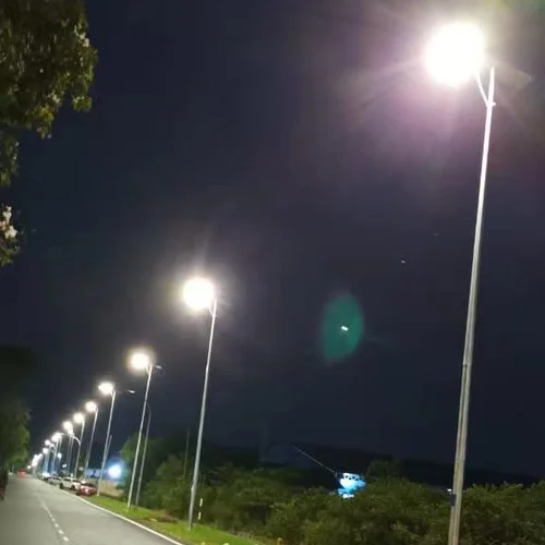 Una fila di lampioni solari ad alto palo della serie QH di Sungreat Energy illumina un'autostrada di notte, garantendo una visibilità sicura alla guida grazie a una distribuzione della luce brillante e uniforme.