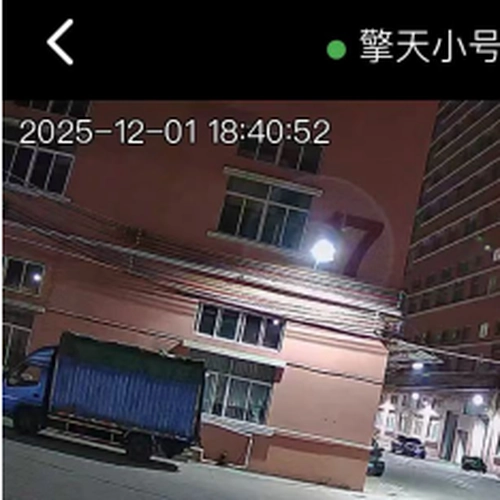 Night surveillance view from FNC series integrated solar street light with built-in CCTV camera showing city building