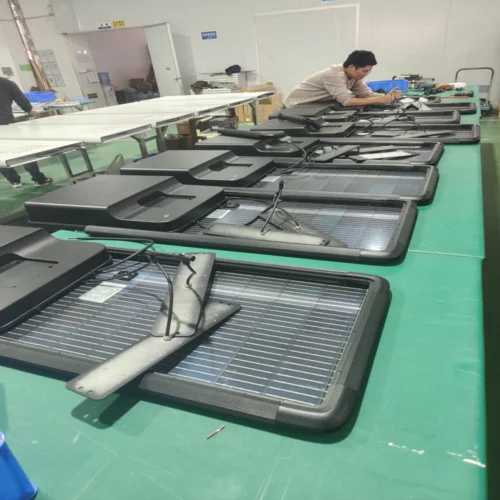 QM series 100W integrated solar street lights on the assembly line with solar panels and housings during production