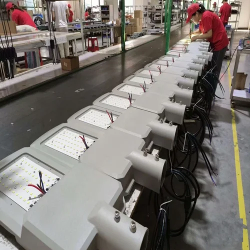 Catena di montaggio in fabbrica per la produzione di lampioni a LED della serie LA di Sungreat Energy, con operai intenti ad assemblare le unità.